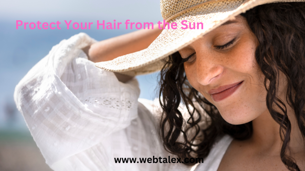 A woman wearing a stylish wide-brimmed hat, protecting her hair from the sun's rays.