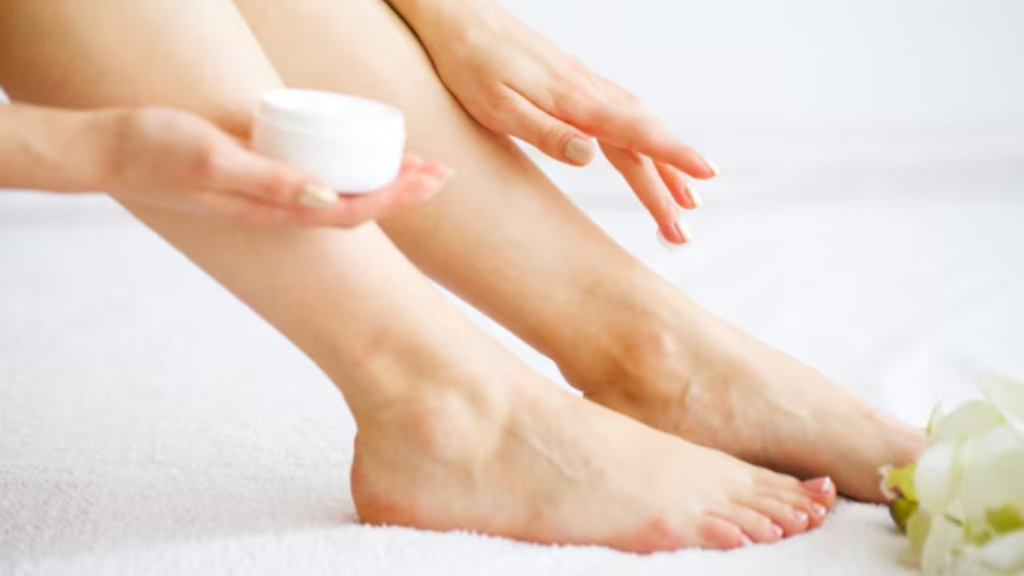 A beautiful woman applying hand and foot whitening cream to her foot.